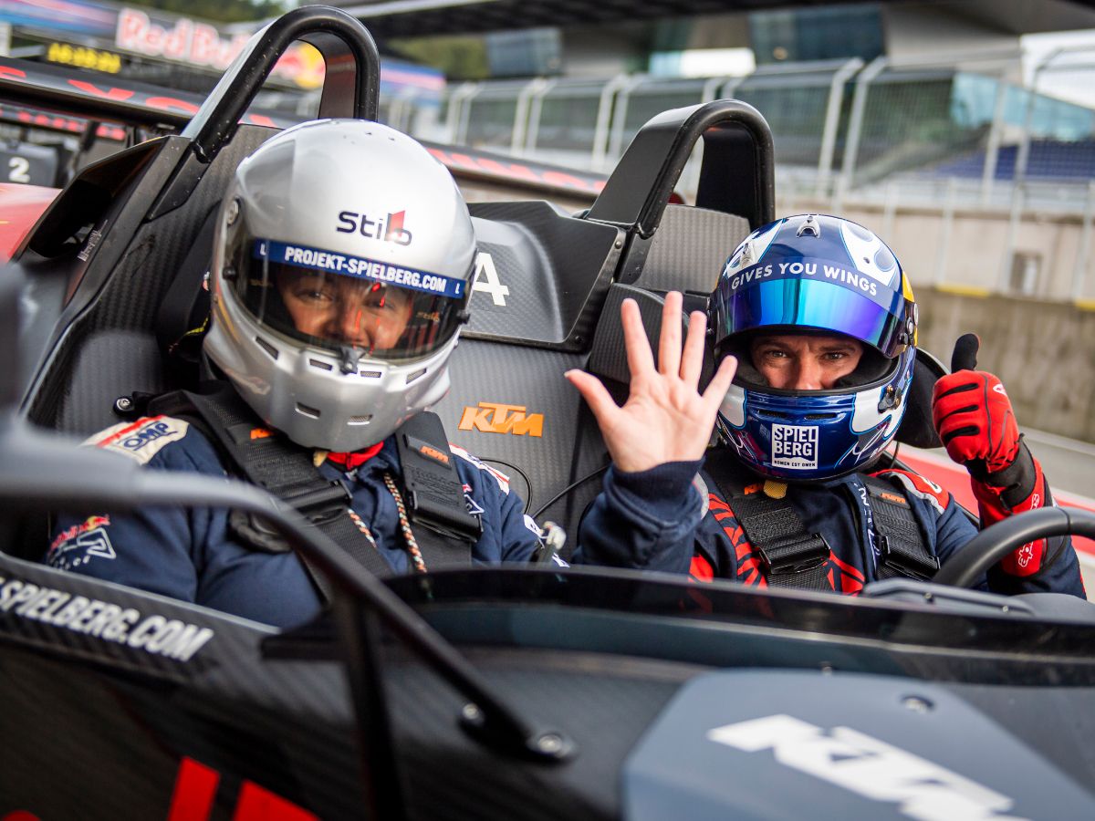 A man waving out of a KTM X-Bow
