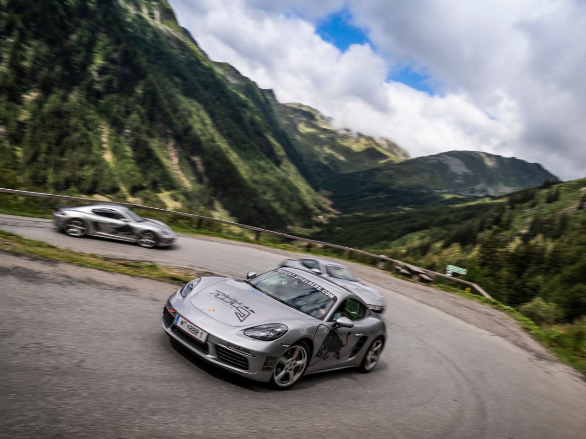 Porsche 718 Cayman S driving through a hairpin in the mountains