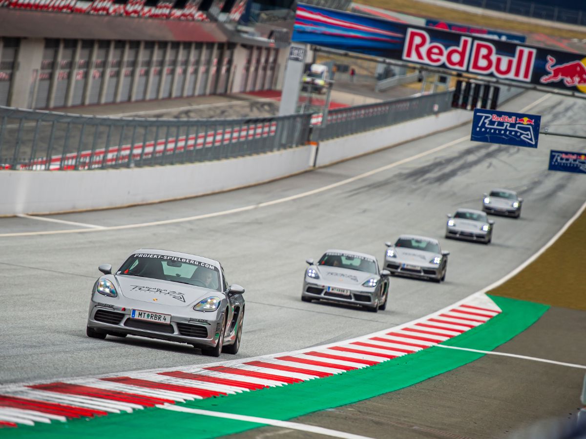 Multiple Porsche driving  on the start finish straightaway